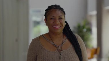 Afro-Amerikan kadın portresi sıcak bir gülümseme, doğal bir ifade, özgüven, nezaket ve otantik bir sevinç göstermektedir.