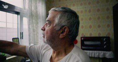 Mutfak penceresinden dışarı bakan yaşlı bir adam içsel bir ifadeyle, yalnızlığı, yaşlanmayı ve günlük hayattaki kişisel yansımaları temsil ediyor.