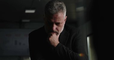 İşletme yöneticisi, şirket yönetim kurulu toplantısında arka planda performans çizelgeleriyle el pençe divan dururken düşüncelere daldı.