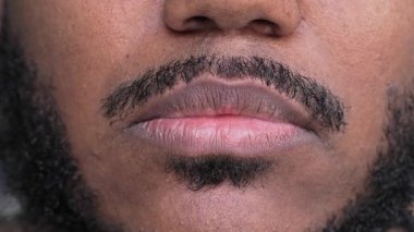 Dudaklarını ve sakalını kapatır mısın? Genç siyahi adam, tıraş detaylarını kombinasyon ifadesiyle gösteriyor.