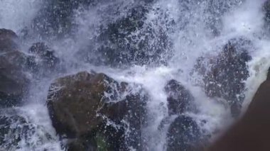 Güçlü şelale kayalara sıçrıyor ve Ultra yavaş çekimde havayı sisliyor. Yüksek hızlı kamerayla çekiliyor.