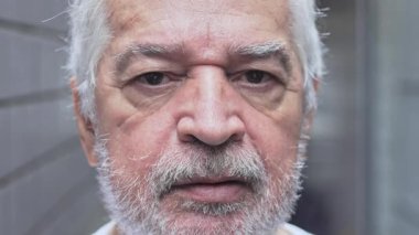 Yaşlı bir adamın suratını yoğun bir tarafsız bakışla ve ciddi bir ifadeyle sessiz ve düşünceli bir şekilde resmetmek.