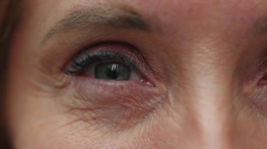 Kadınların göz ve kirpiklerinin makro yakın çekimi cilt dokusunu ve duygusal sakinliği yansıtan samimiyet ve yansıtıcı duyguyu gösteriyor..