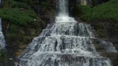 Kademeli dağ şelalesi Ultra yavaş çekimde yüksek hızlı kamerayla kayalık teraslardan aşağı iniyor.
