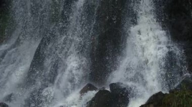 Üst üste gelen şelale çarpan kaya yüzeyinin yakın çekimi, yüksek hızlı bir kamerayla ultra yavaş çekimde, gücü, dokuyu ve doğal hareketin ham enerjisini gösteriyor.