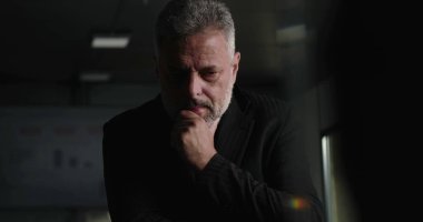 İşletme yöneticisi, şirket yönetim kurulu toplantısında arka planda performans çizelgeleriyle el pençe divan dururken düşüncelere daldı.