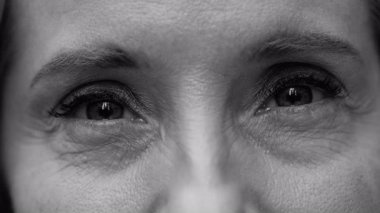 Orta yaşlı kadınların gözlerinde mutluluk ve samimiyet, tenin ince ayrıntıları ve kirpikleri siyah ve beyaz olarak duyguları ve özgünlüğü vurguluyor..