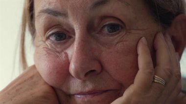 Sakin ve düşünceli bir ifadeyle yüzünü dinlendiren yaşlı bir kadın şefkat, dinginlik ve yaşlanmanın duygusal derinliğini gösteren samimi bir portre.