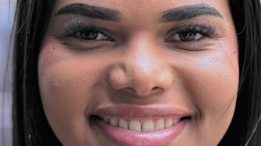 Tanımlanmış kaşları ve kirpikleriyle neşeli kadın yüzünün yakın görüntüsü ifade ve kişilikle dolu güzel bir gülümsemeyi çerçeveliyor.