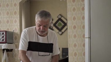 Son sınıf öğrencisi masa temizliyor ve ev içi ev ortamında ev işi yaparken bardakları batırıyor..