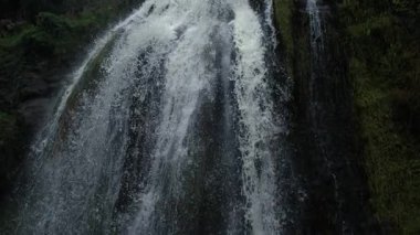 Uzun şelale, yüksek hızlı bir kamerayla Ultra yavaş çekimde kayalıkların üzerinden düşüyor.