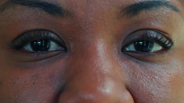 Afrika kökenli Amerikalı kadınların gözlerinin aşırı yakınlığı sıcaklığı ve kendine güveni, doğal deri dokusu ve bakışlarında yansıyan yumuşak ışıkla.