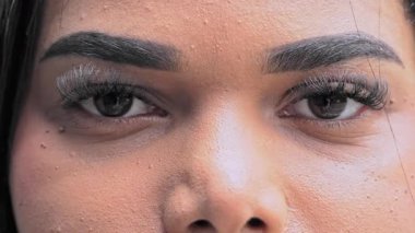 Kalın kaşları ve güçlü bir tarafsız bakışla tanımlanmış kirpikleri olan etkileyici kadın gözlerinin yakın çekimi.