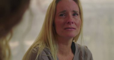 Grup terapisi sırasında duygu yüklü ağlayan kadın empati, iyileşme ve destek alanlarında acı ve hassasiyetini ifade ediyor.