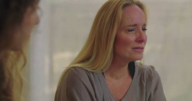 Grup terapisi sırasında duygu yüklü ağlayan kadın empati, iyileşme ve destek alanlarında acı ve hassasiyetini ifade ediyor.