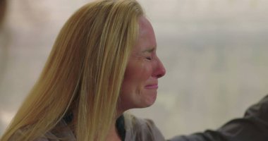 Grup terapisi sırasında duygu yüklü ağlayan kadın empati, iyileşme ve destek alanlarında acı ve hassasiyetini ifade ediyor.