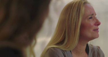 Grup terapisi sırasında duygu yüklü ağlayan kadın empati, iyileşme ve destek alanlarında acı ve hassasiyetini ifade ediyor.