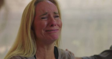 Grup terapisi sırasında duygu yüklü ağlayan kadın empati, iyileşme ve destek alanlarında acı ve hassasiyetini ifade ediyor.