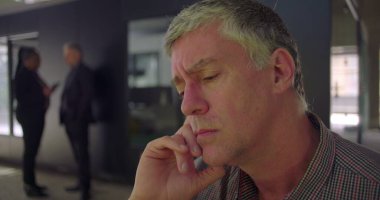 Modern ofis ortamında, gözleri kapalı, dalgın ve düşünceli bir şekilde dinlenen orta yaşlı adamın yüzünü kapatın. Çalışma gününde düşünceli bir an.