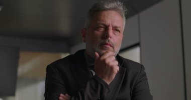 Çene ve odaklı ifade ile olgun iş adamlarına yakın çekim Modern ofisin şirket toplantısında karar verirken