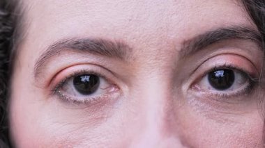 Kadınların Yumuşak Yakın Çekimi. Koyu Gözler. Makyajla kaplanmış, ince deri dokusu ve zar zor görünen kırışıklıklar..