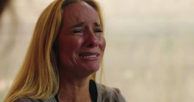 Grup terapisi sırasında gözyaşlarına boğulan kadın destek veren ve güvenli bir ortamda acısını paylaşırken duygularla dolup taşıyor.