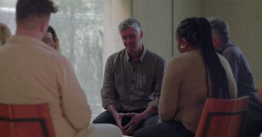 Erkekler, grup terapisi sırasında duygusal olarak konuşurlar. Çevreleri sessiz çemberlerle çevrilidir. Hassasiyet ve bağlantı anında açılır.