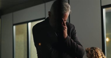 Düşünceli bir işadamı, şirket tartışması sırasında ciddi kararları değerlendirirken el pençe divan duruyor. 