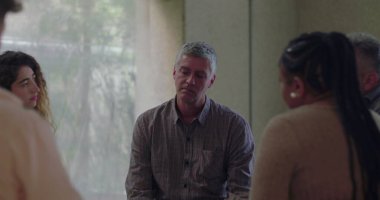 Erkekler, grup terapisi sırasında duygusal olarak konuşurlar. Çevreleri sessiz çemberlerle çevrilidir. Hassasiyet ve bağlantı anında açılır. 