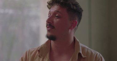 Grup terapisi sırasında kişisel hikâyesini ifade eden bir adam, empati ve tedarikçi çemberi içinde dinlerken duygu ve açıklıkla konuşur.