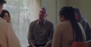 Erkekler, grup terapisi sırasında duygusal olarak konuşurlar. Çevreleri sessiz çemberlerle çevrilidir. Hassasiyet ve bağlantı anında açılır. 