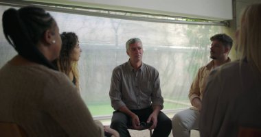 Orta yaşlı bir adam terapi çemberinde samimi itiraflar sunuyor. Güçlü hassasiyet ve doğruluk anlarında destek grubuyla duygusal bir buluş paylaşılıyor.