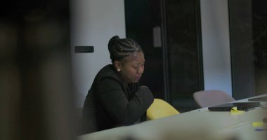 Şirket ofisindeki afro-amerikan iş kadını sessiz hüsranla yüzünü kapatıyor, işyeri talepleri ve yorgunluğu yüzünden duygusal olarak tükenmiş. 