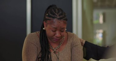 Destek grubu üyeleri ağlayan kadını teselli etmeye çalışıyor. Duygusal çöküntü, empati ve iyileşme camiası ortamında teşvik ile karşılandı.