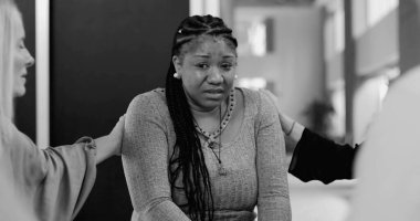 Duygusal terapi sırasında teselli bulan ağlak kadın, grup üyeleri güçlü bir paylaşımlı hassasiyet anında, siyah ve beyaz 