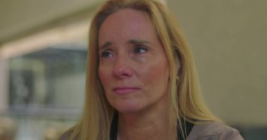 Grup terapisi sırasında acı ifade eden ağlak bir kadın zor duyguların üstesinden gelirken destekleyici akranları tarafından görülmek ve duyulmak.