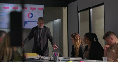 Gergin ofis toplantısı sırasında gergin bir yöneticinin el ele tutuşması, stresli performans değerlendirmesine cesaretinin kırılmasına yol açtı.