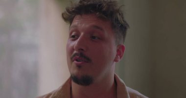 Grup terapisi sırasında kişisel hikâyesini ifade eden bir adam, empati ve tedarikçi çemberi içinde dinlerken duygu ve açıklıkla konuşur.