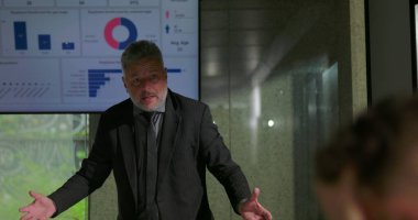 Öfkeli yönetici, gergin ofis toplantısında çalışanlarla yüzleşirken, takım üyeleri konferans masasının etrafında kaygı ve utançla tepki veriyorlar.