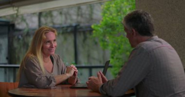 Açık ofis ortamında masadaki dizüstü bilgisayarla erkek arkadaşa kadın profesyonel açıklama fikri