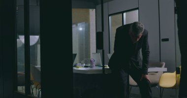 Kurumsal toplantıdan sonra modern ofis yönetim kurulunda duygusal bir anda öne doğru eğilmiş hayal kırıklığına uğramış işadamı.