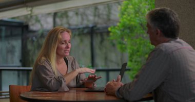 Açık ofis ortamında masadaki dizüstü bilgisayarla erkek arkadaşa kadın profesyonel açıklama fikri