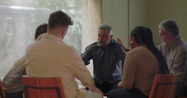 Katılımcılar ellerini sırtına ve kollarına koyup hassas anlarında rahatlık sunarken grup terapi üyelerinden duygusal destek alıyor.