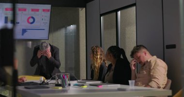 Gergin ofis toplantısı sırasında gergin bir yöneticinin el ele tutuşması, stresli performans değerlendirmesine cesaretinin kırılmasına yol açtı.