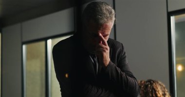 Düşünceli bir işadamı, şirket tartışması sırasında ciddi bir karar verirken el pençe divan duruyor.