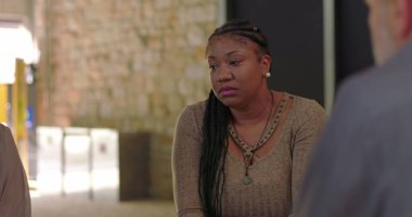 Terapi seansı sırasında başını eğen kadın empati, yansıma ve destek ortamında derin duygusal acılara göğüs geriyor.