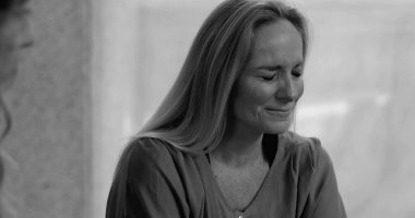 Grup terapisi sırasında ağlayan bir kadın, incinebilirlik ve yansıma anında derin acıları ifade ederken, siyah ve beyaz.