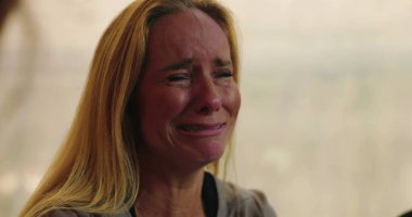 Grup terapisi sırasında gözyaşlarına boğulan bir kadın destek ve güvenli ortamda acısını paylaşırken duygularla dolup taşıyor.