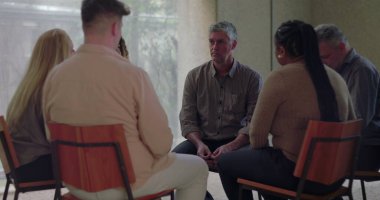 Grup terapisi sırasında başları eğik bir şekilde sessizce oturan adam diğerlerinin sessizce izlediği gibi, sakin ve düşünceli bir şekilde çemberin içinde toplandı.