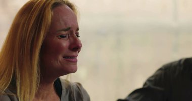 Grup terapisi sırasında gözyaşlarına boğulan bir kadın destek ve güvenli ortamda acısını paylaşırken duygularla dolup taşıyor.